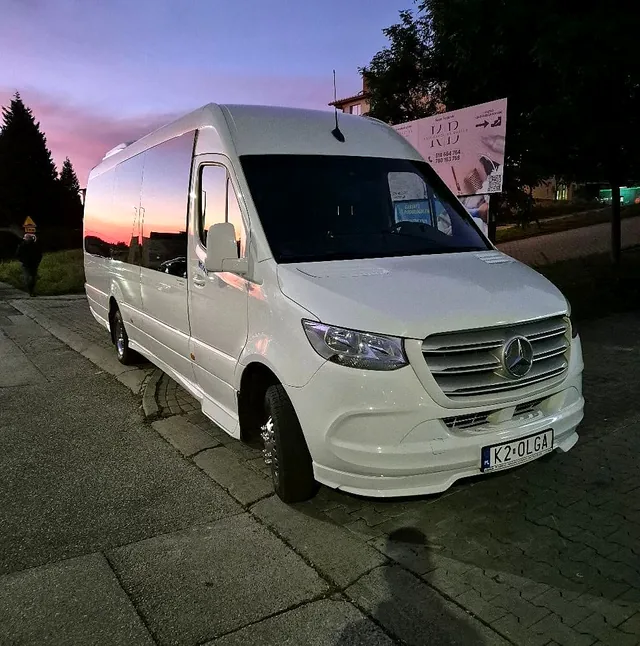 Biały bus Mercedes Sprinter VIP z rejestracją K2 OLGA o zachodzie słońca